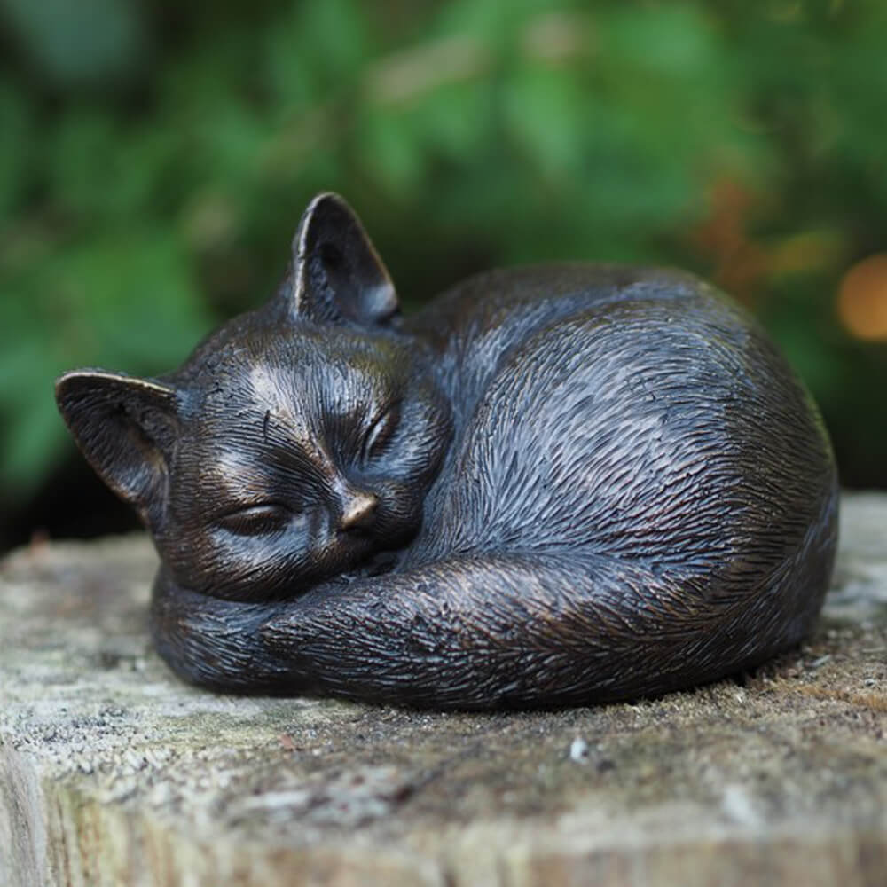 Décoration de jardin en bronze représentant un chat endormi sur une pierre
