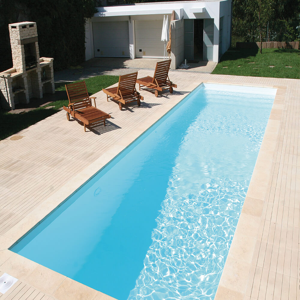 Vue d'une piscine rectangulaire avec des chaises longues en bois et une cabane de jardin en arrière-plan