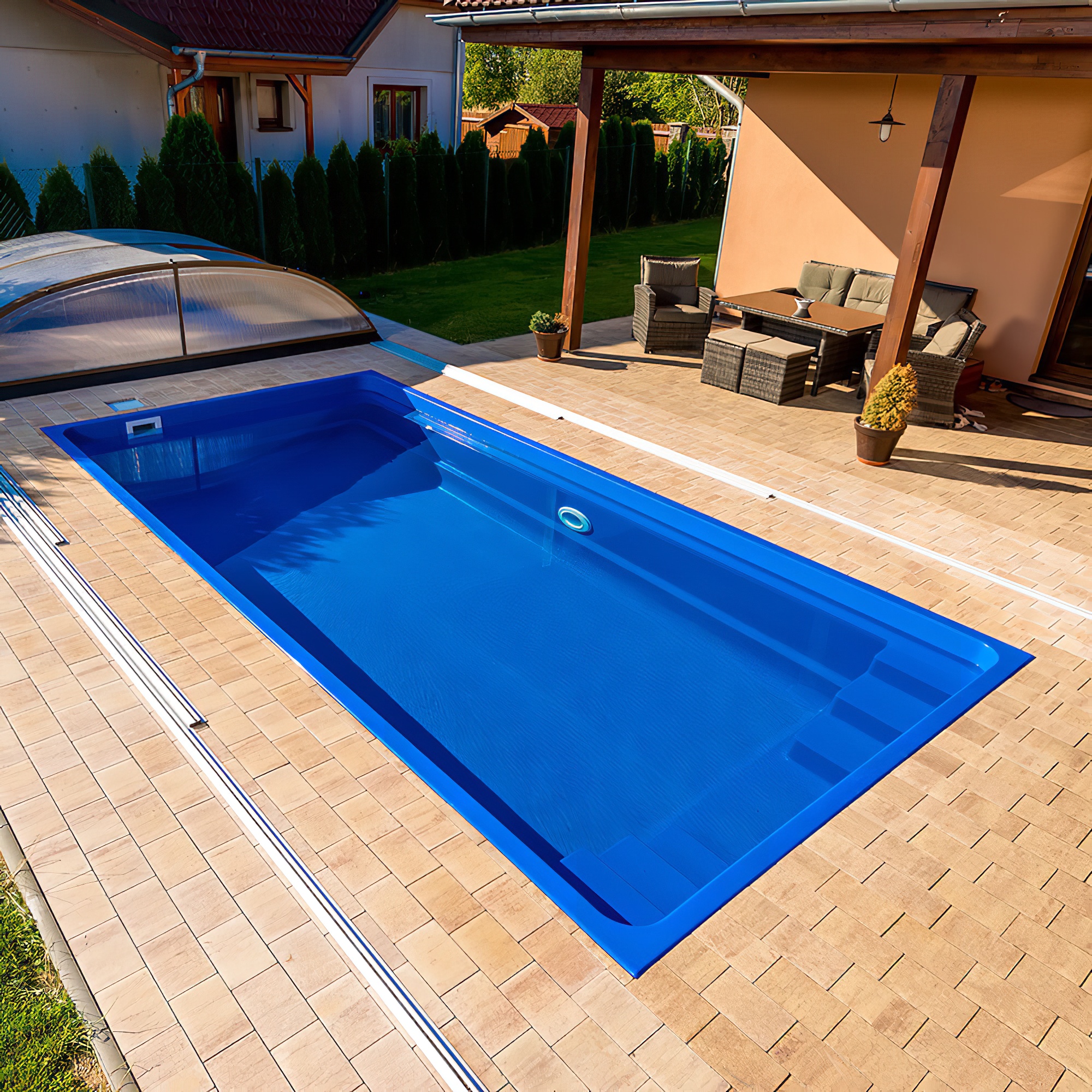 Blauer Swimmingpool mit Abdeckung auf einer Terrasse neben Gartenmöbeln