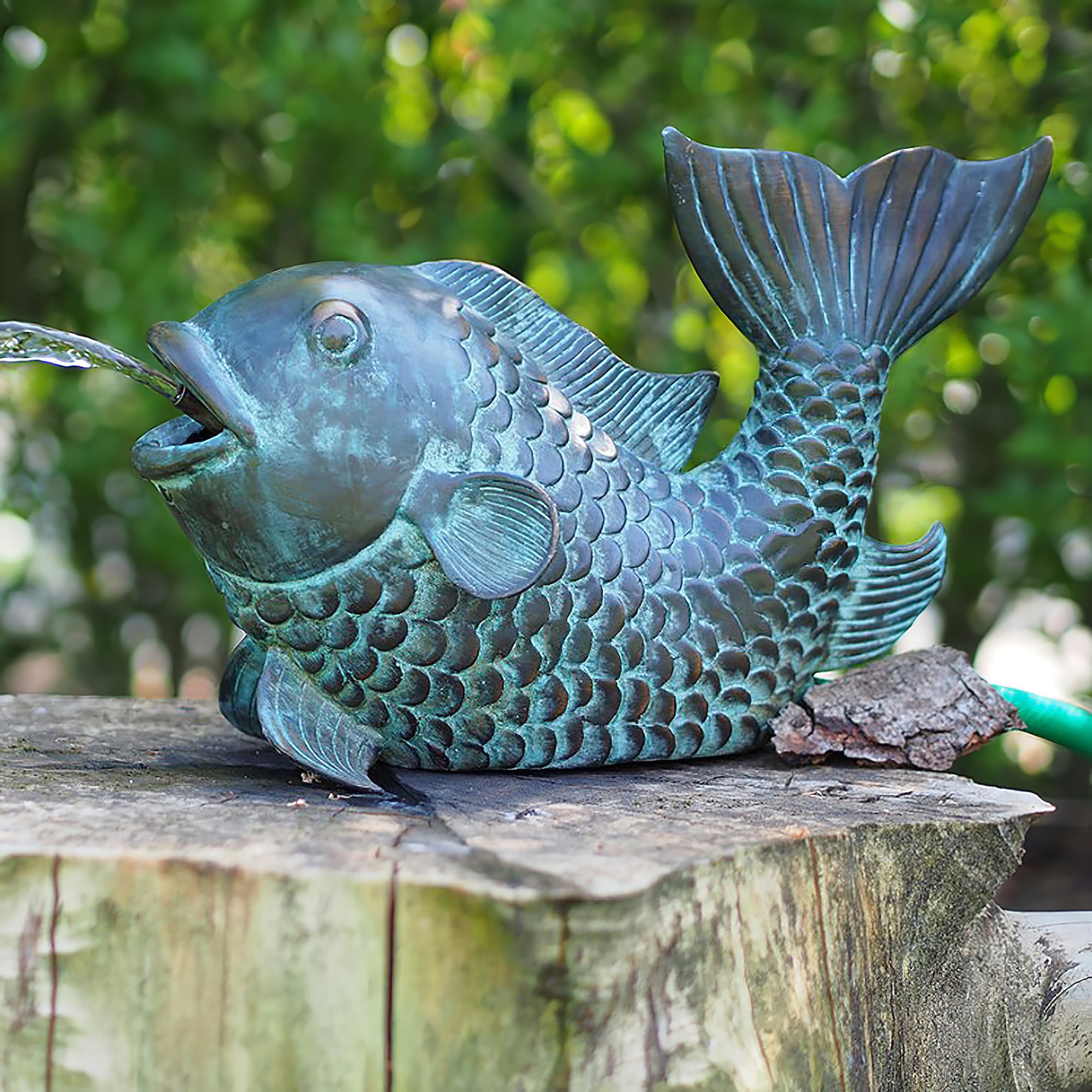 Fontana da giardino di bronzo a forma di pesce su ceppo d'albero