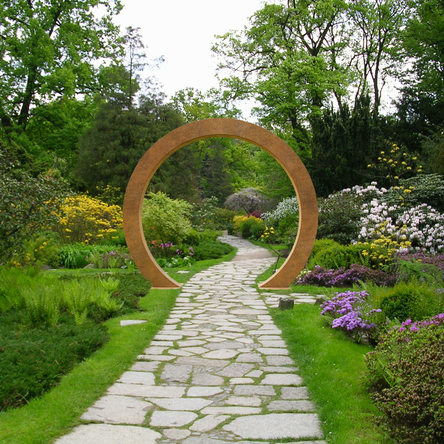 Sentiero lastricato che attraversa un arco da giardino con fiori colorati e piante verdi