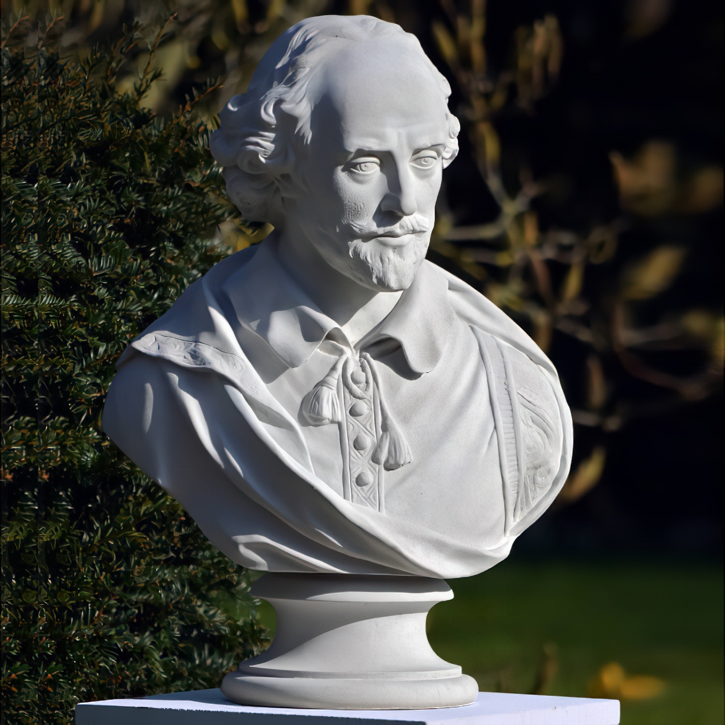 Busto scolpito bianco di uno scrittore classico nel giardino davanti a cespugli verdi