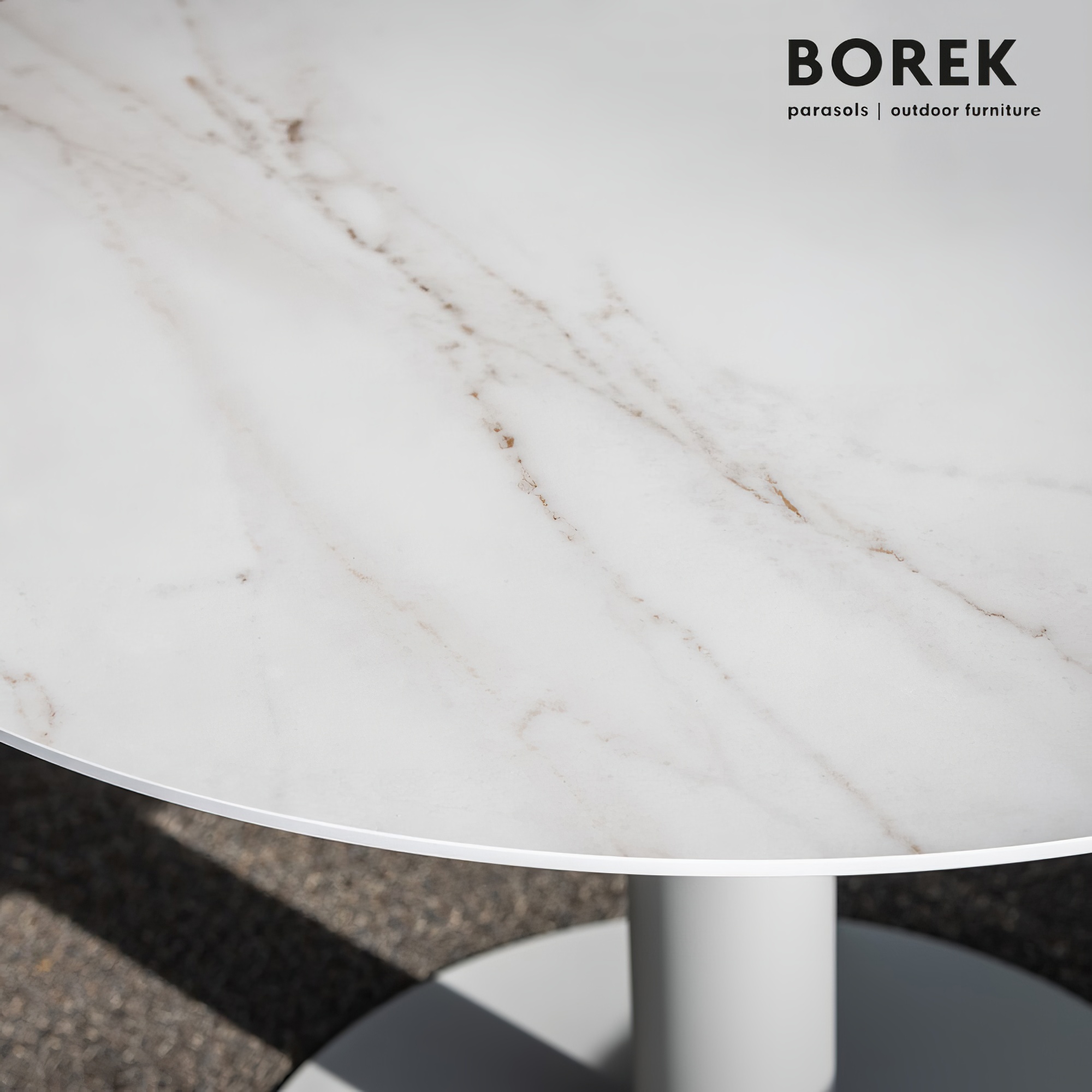 Table de jardin ronde avec surface blanche en marbre sur sol en béton
