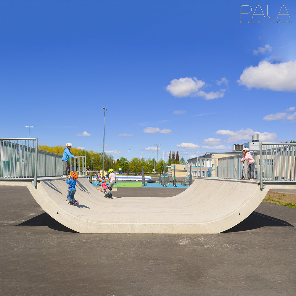 Bambini che fanno skateboard su una rampa in cemento sotto un cielo sereno, ideale per una decorazione da giardino dinamica