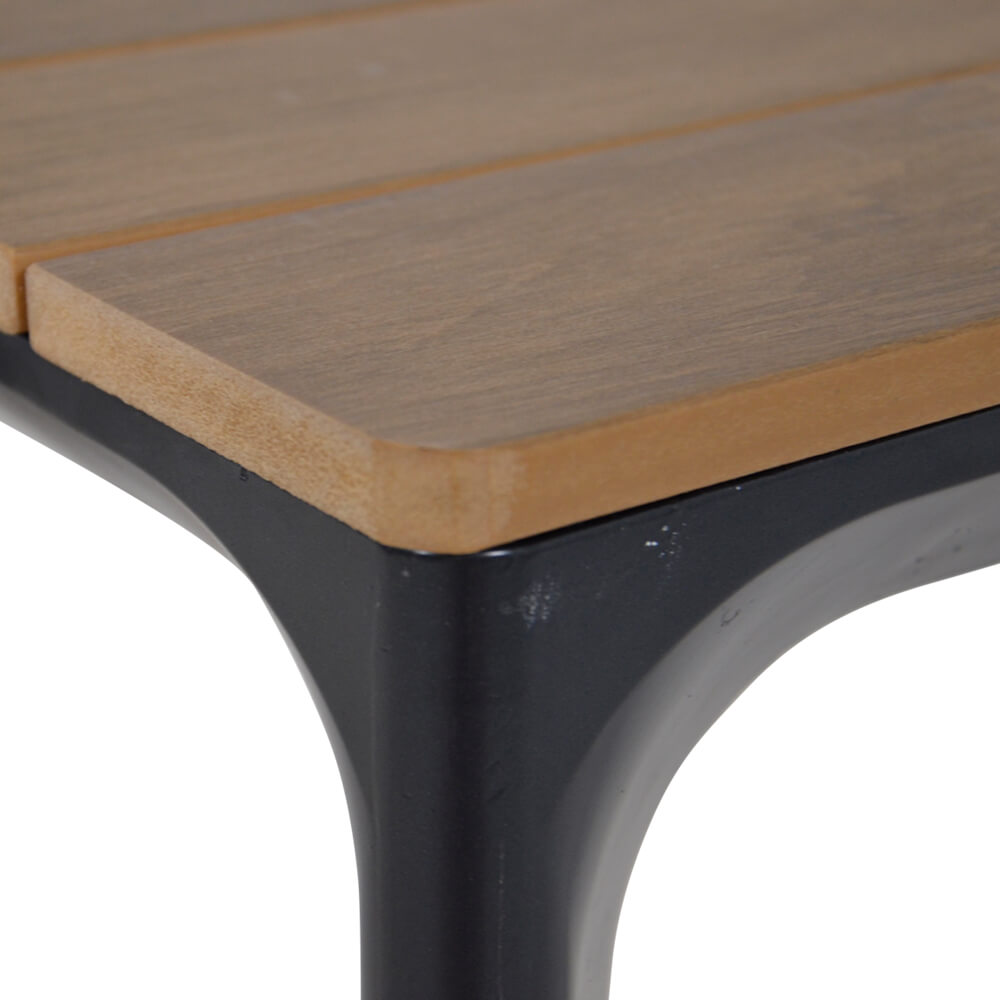Gros plan d'une table de jardin avec plateau en bois naturel et cadre en métal noir