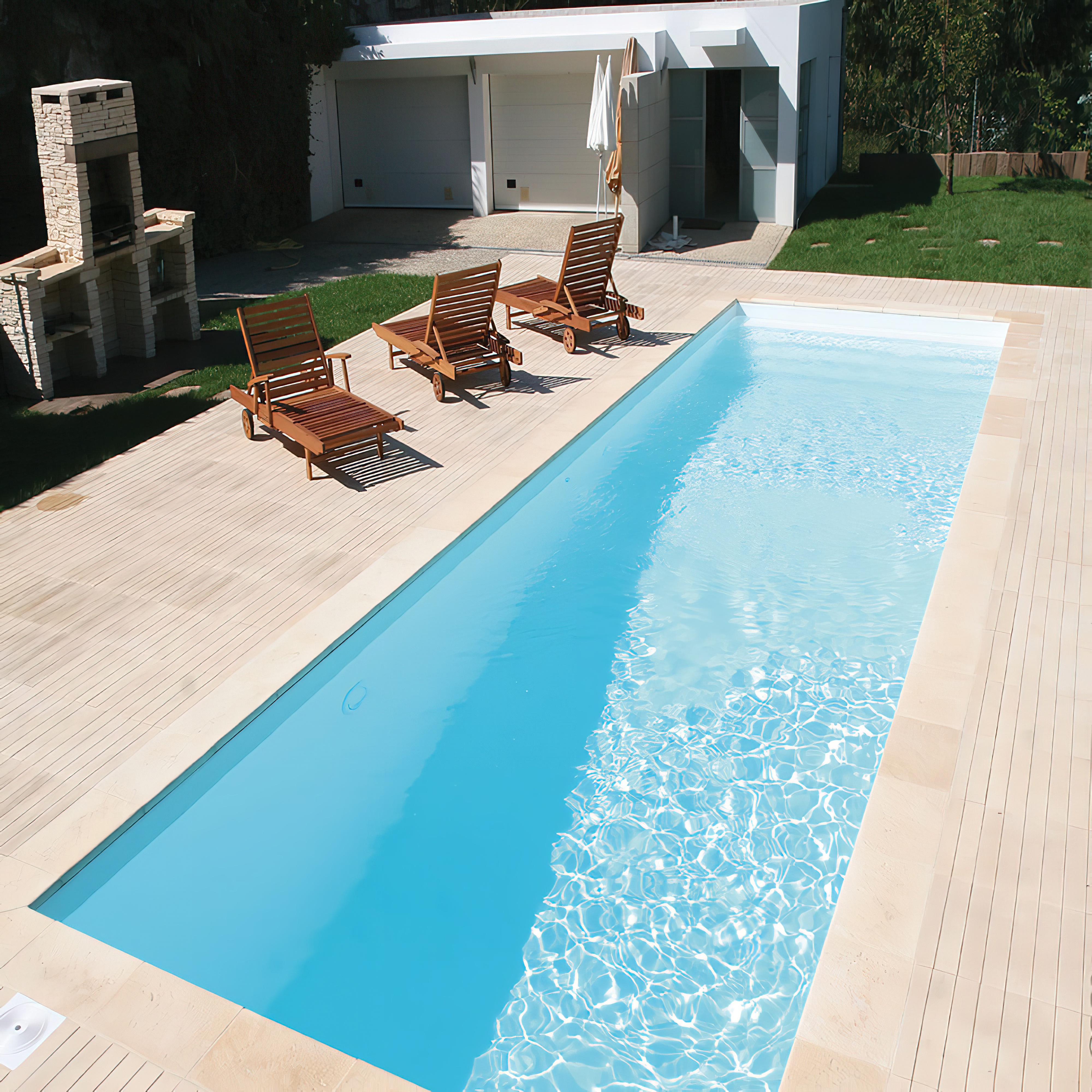 Ein moderner Garten mit einem rechteckigen Pool, Holzliegestühlen und einer Grillstation