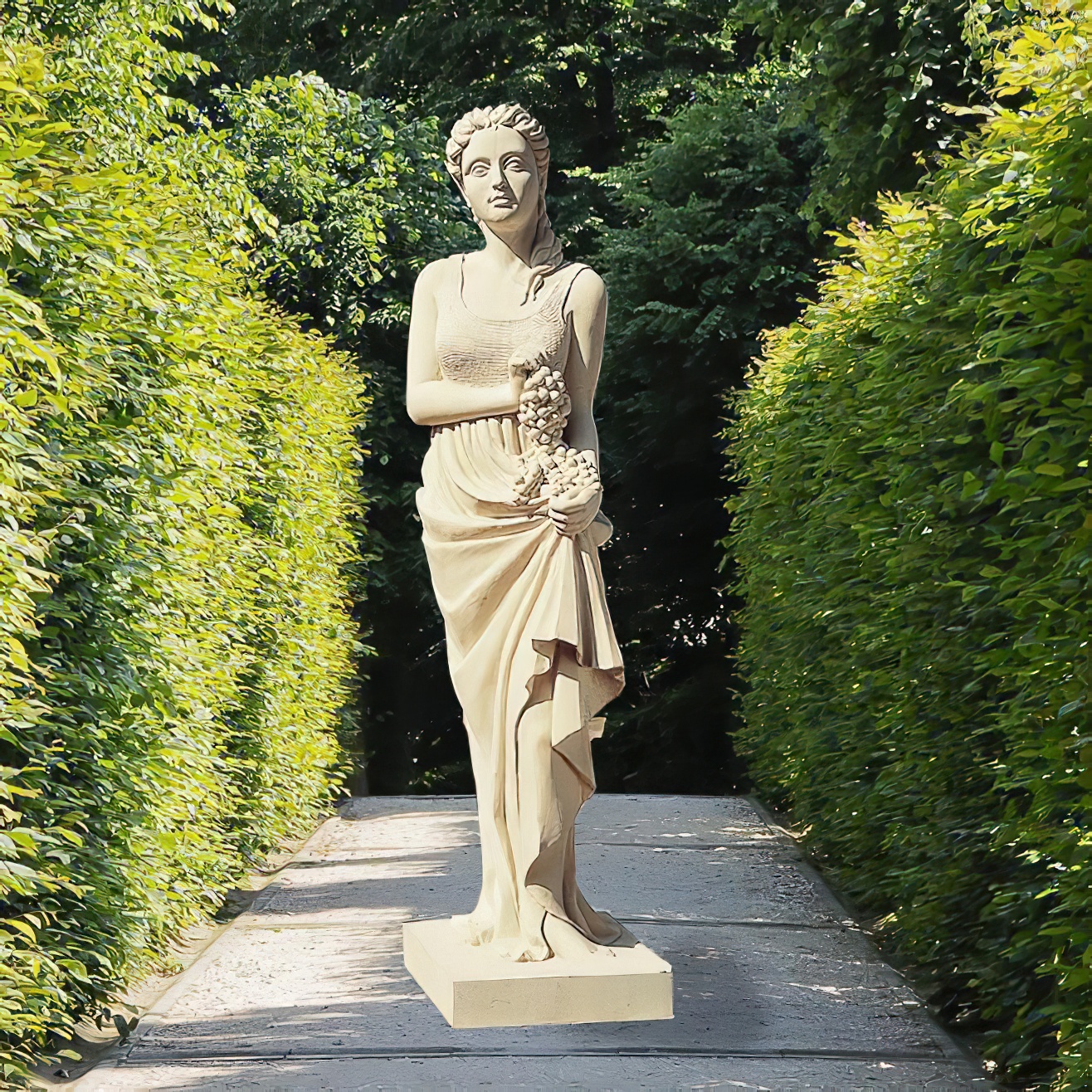 Scultura in pietra di una figura femminile classica su un sentiero del giardino circondato da vegetazione verde
