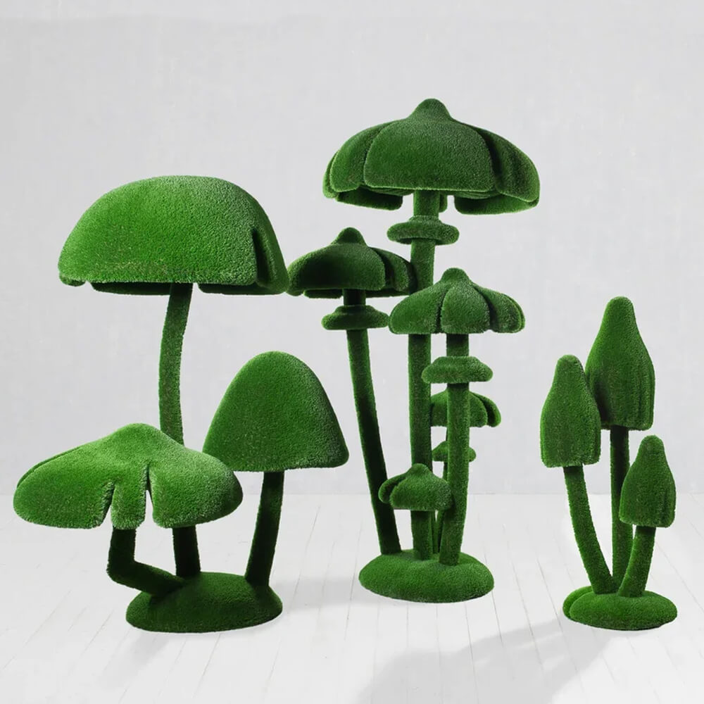 Verschiedene grüne Pilz-Gartendeko aus Kunstmoos auf weißem Hintergrund