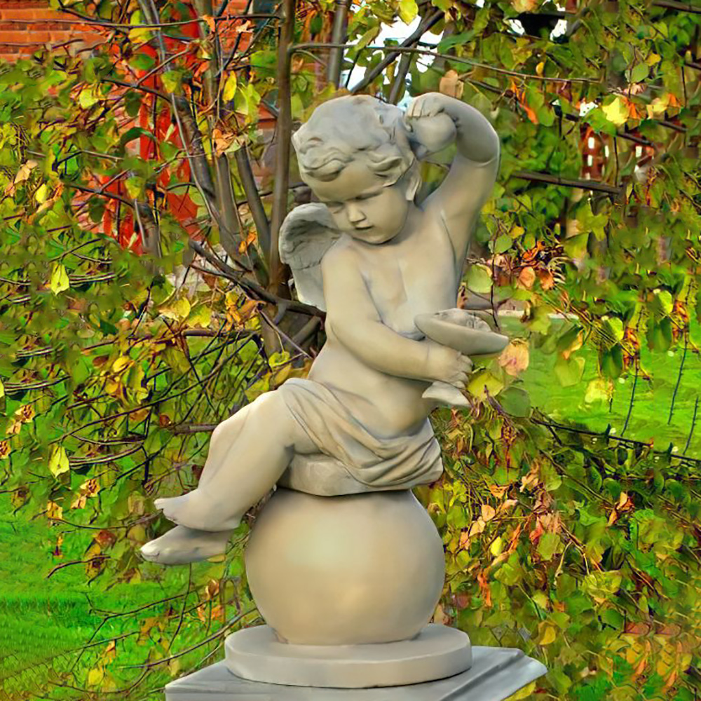 Una statua d'angelo in pietra dettagliata seduta su una sfera, circondata da foglie autunnali in giardino