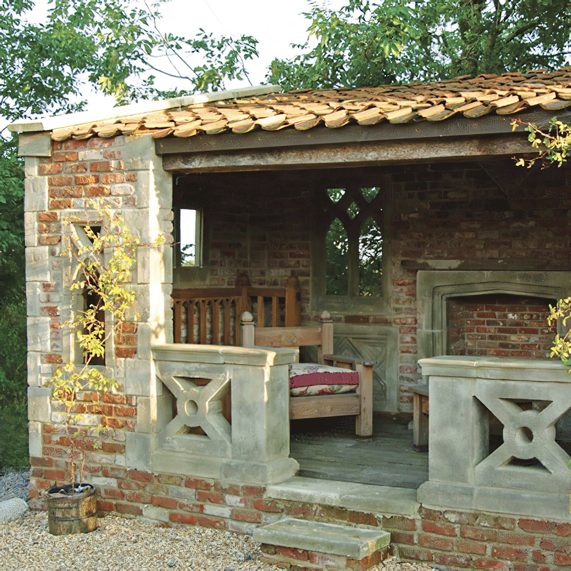 Gartenterrasse mit Steintisch und Sitzbänken unter einem Holzdach mit Tondachziegeln