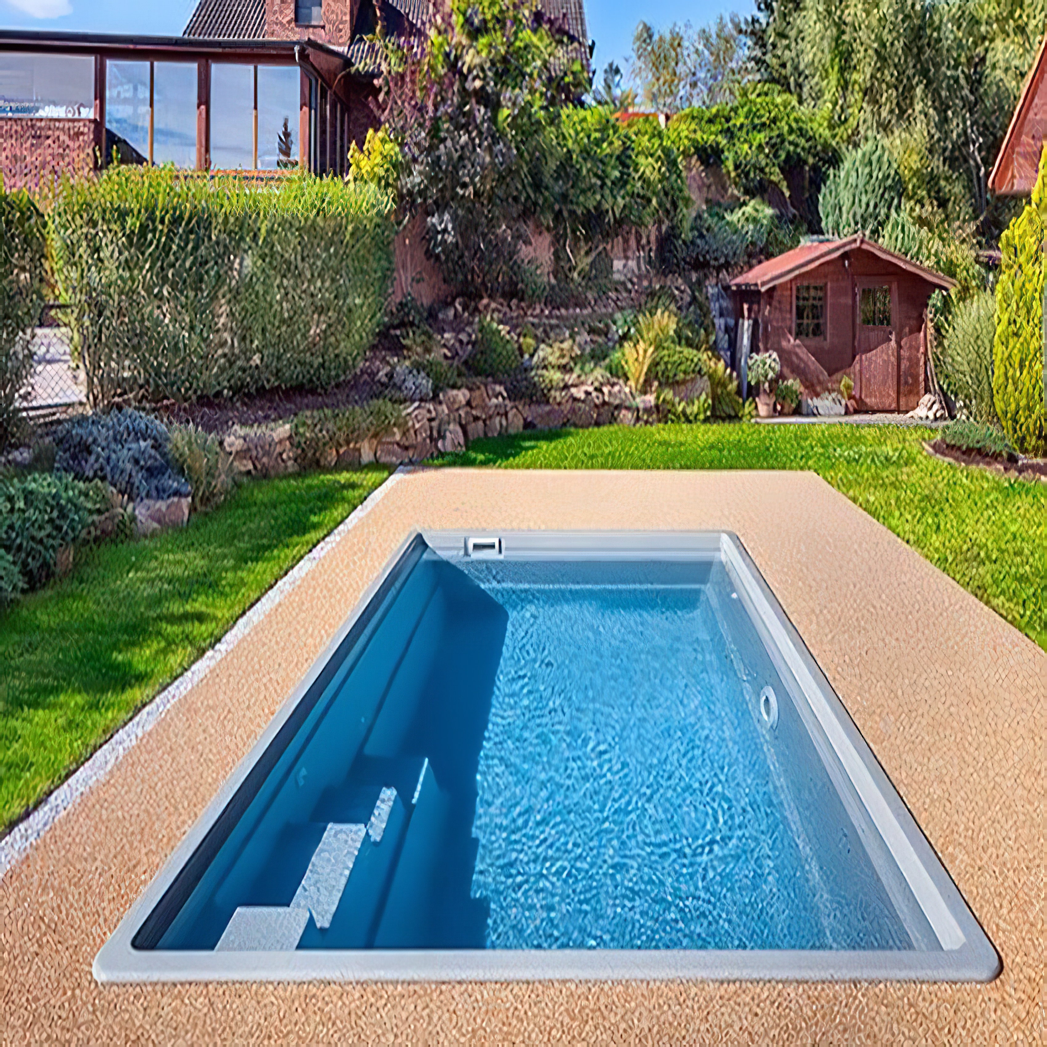 Piscina blu in un giardino curato con prato e casetta da giardino sullo sfondo