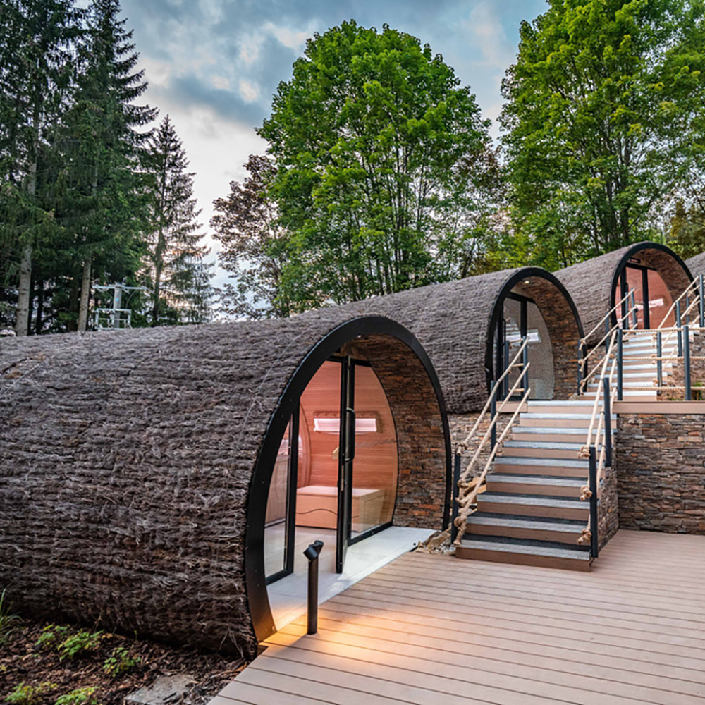 Gartenhaus aus Holz mit runden Eingängen und umliegenden Bäumen im Garten