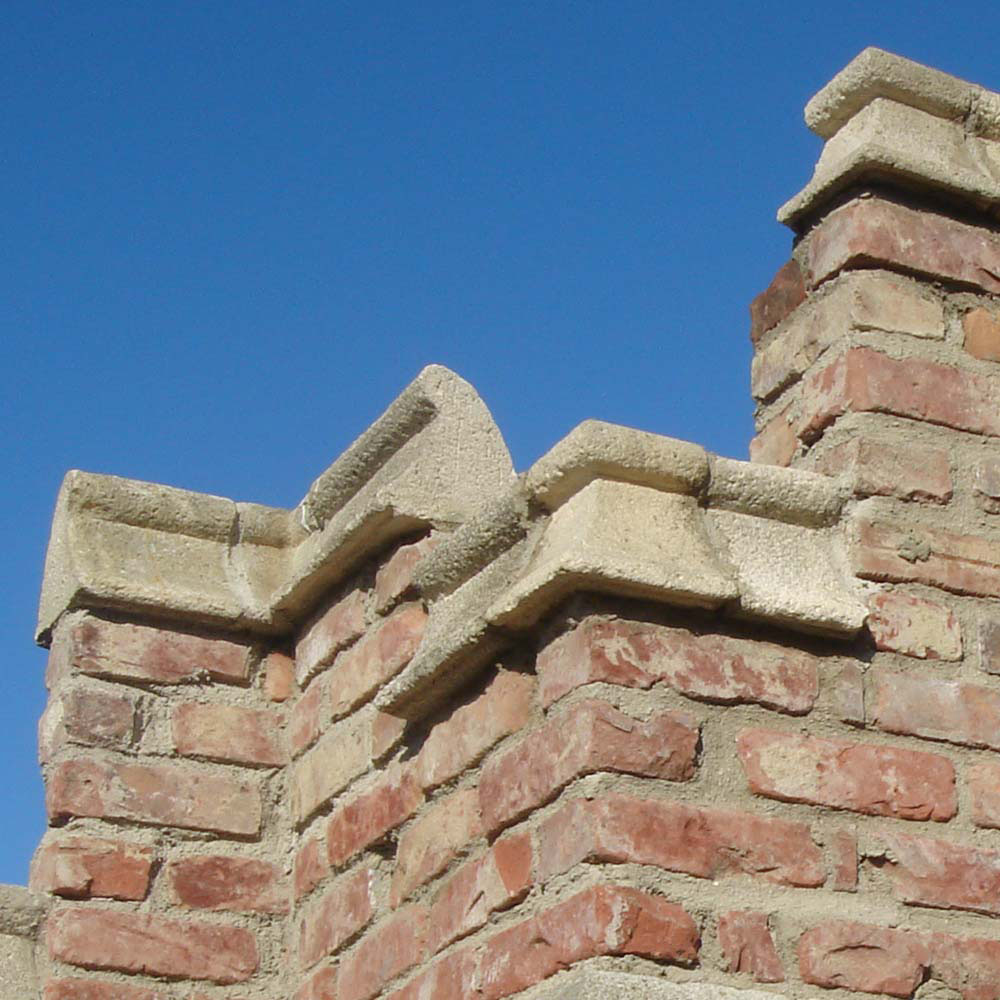 Nahaufnahme einer dekorativen Backsteinmauer unter blauem Himmel