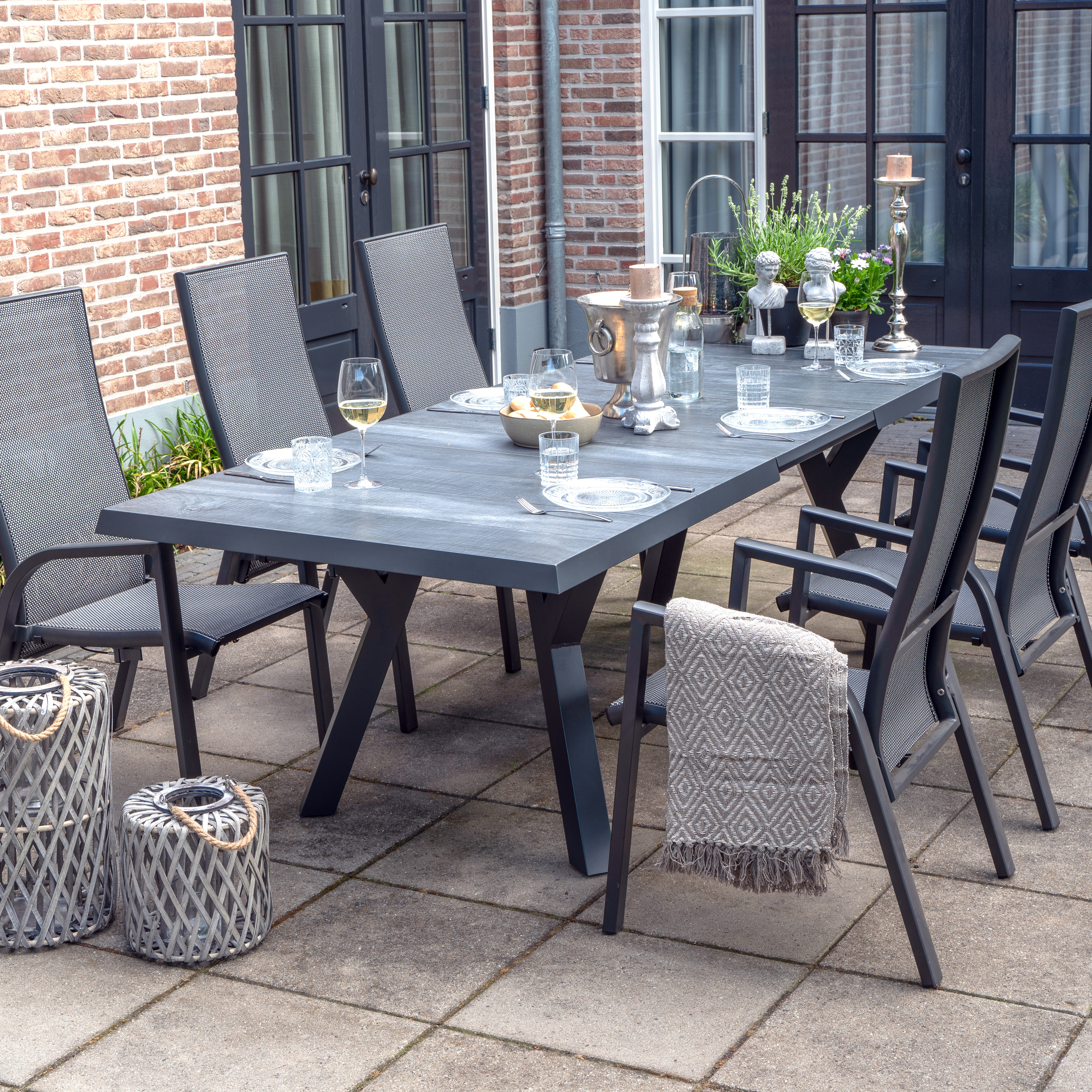 Grande table de jardin moderne avec six chaises et décoration sur la terrasse devant la maison