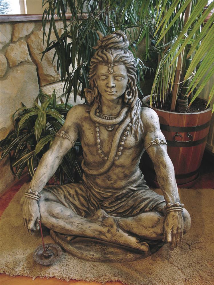 Sculpture de jardin détaillée d'un homme méditant en position du lotus entouré de plantes