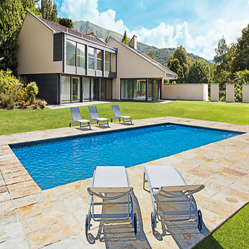 Blick auf einen gepflegten Garten mit Swimmingpool, Liegestühlen und modernem Haus im Hintergrund