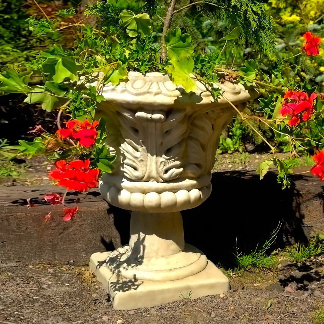 Décoration de jardin avec vase en pierre, fleurs rouges et plantes vertes