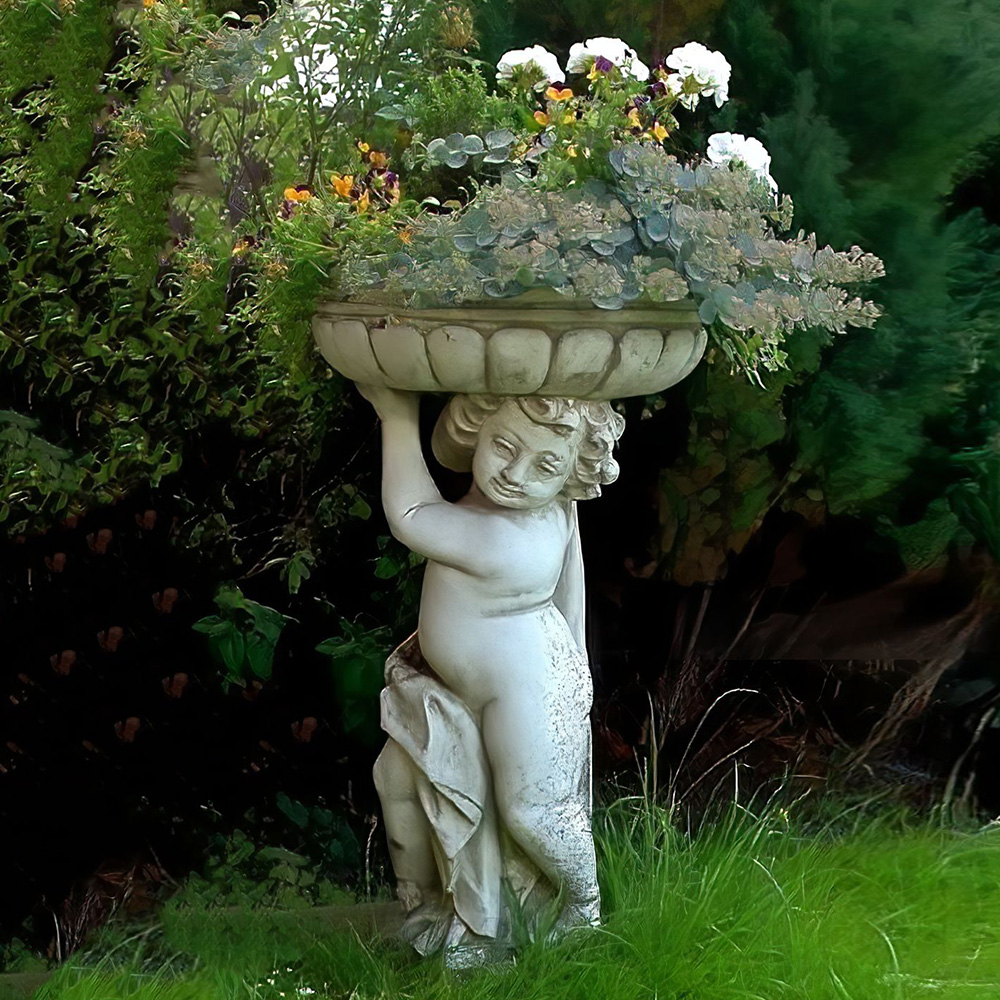 Statua da giardino in pietra di un bambino che sostiene una vasca con fiori bianchi e gialli