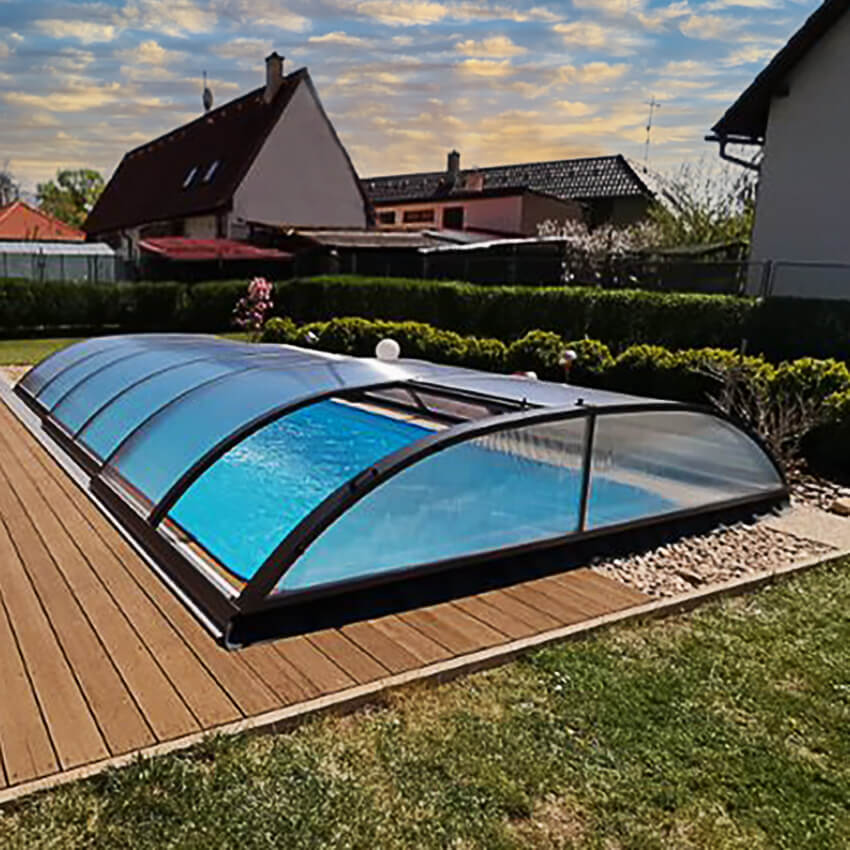 Piscine moderne avec couverture, terrasse en bois et pelouse verte