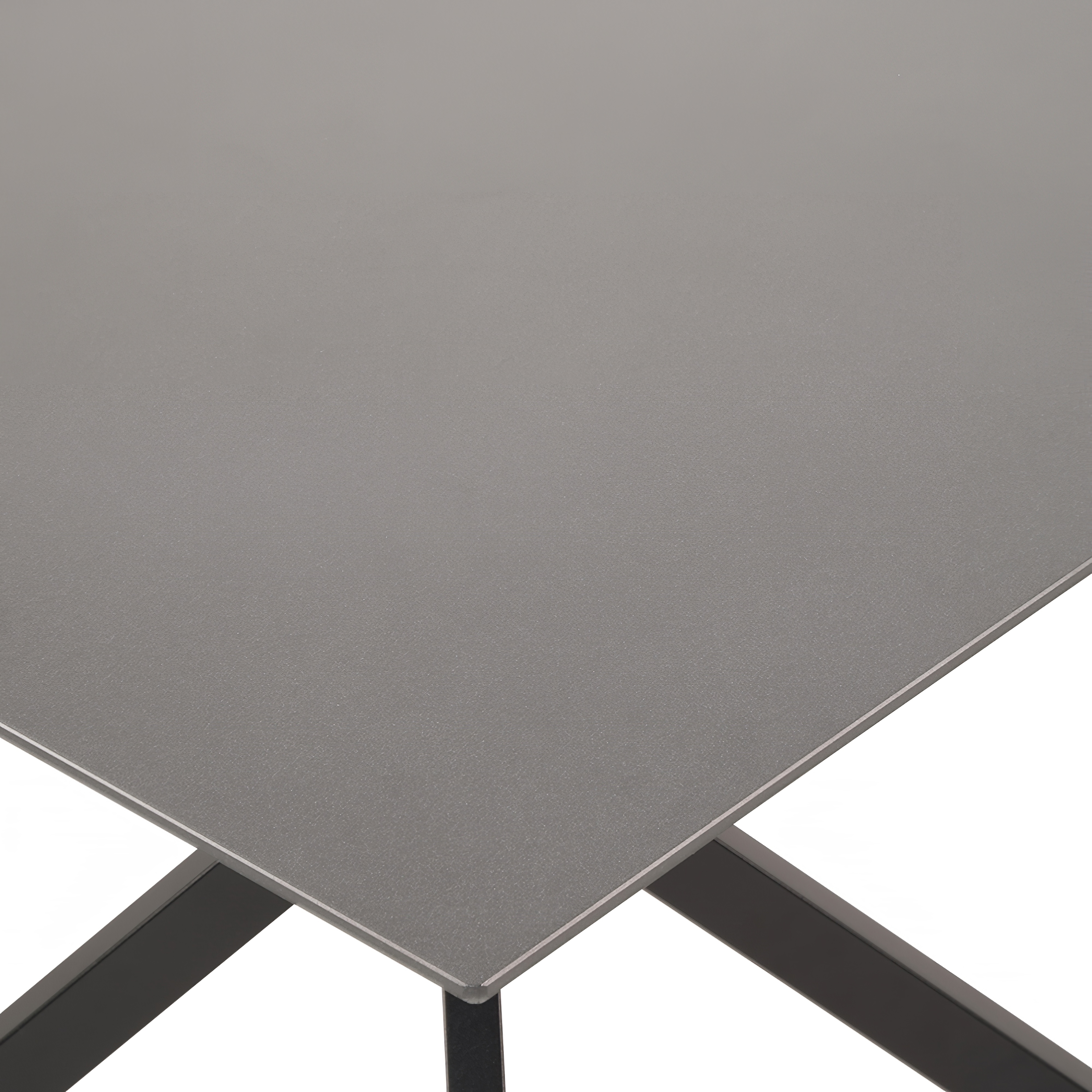 Vue d'angle d'une table de jardin moderne avec surface grise et structure métallique noire