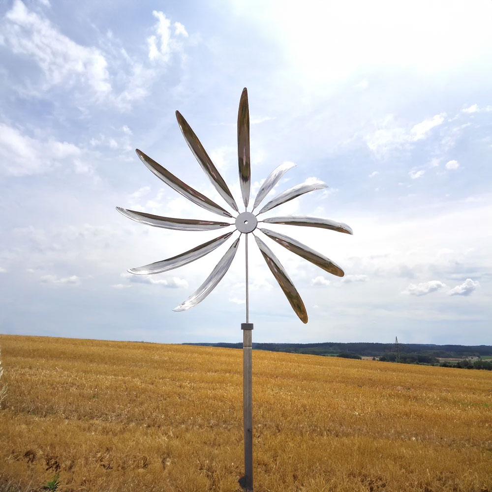 Moderno carillon eolico in metallo installato nel giardino con campo sullo sfondo