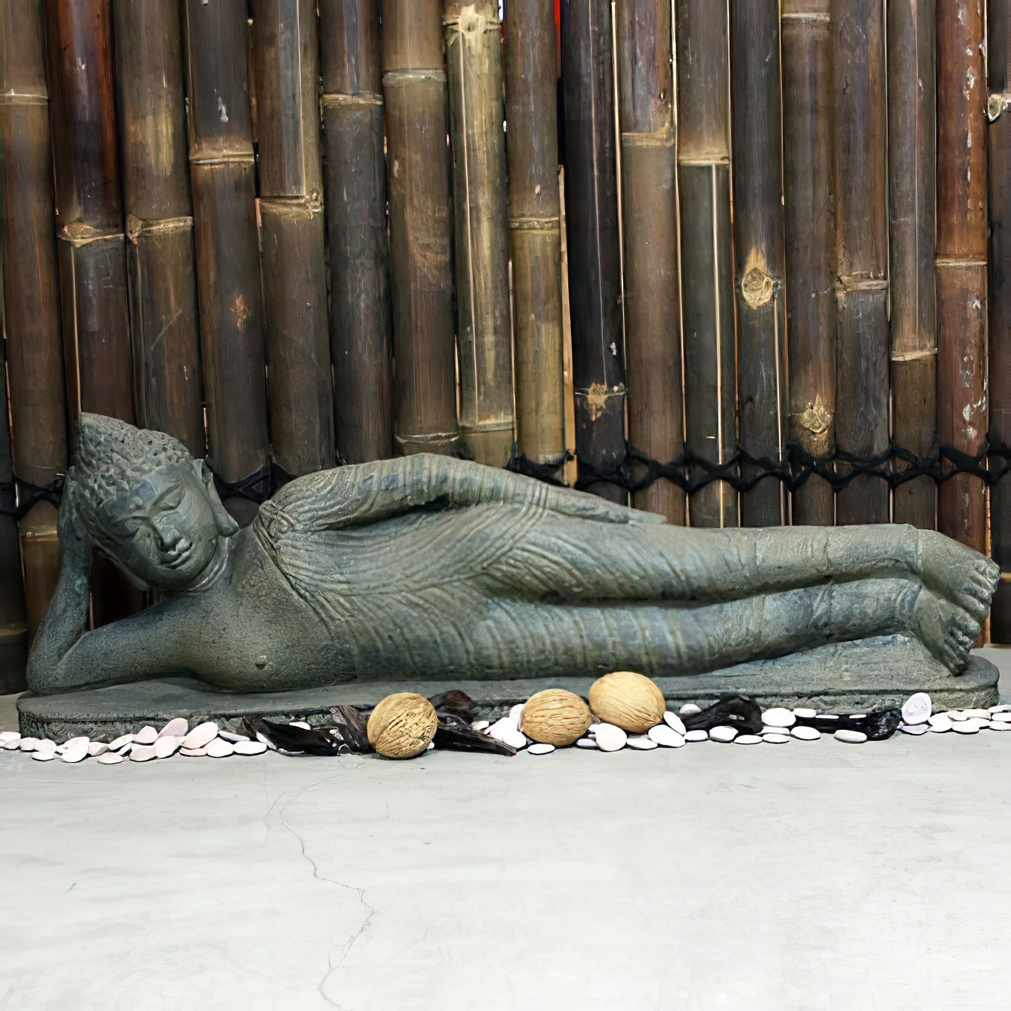 Figure de jardin Bouddha allongé devant un mur en bambou comme décoration de jardin exclusive