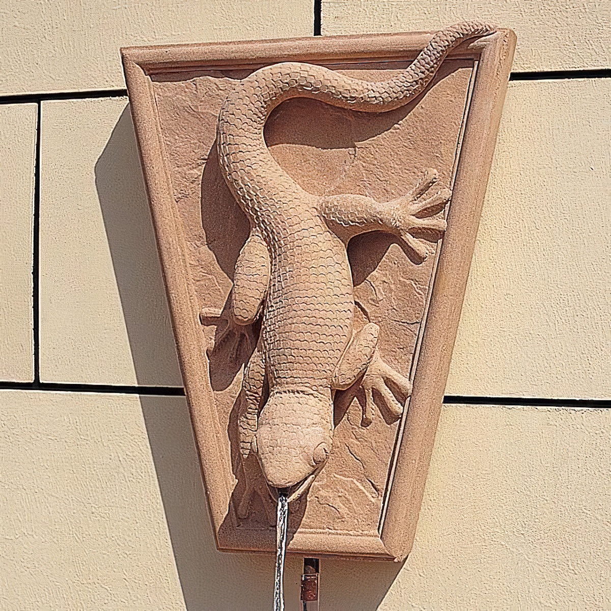 Sandstein-Wandbrunnen mit einem detailreichen Eidechsen-Design, aus dem Wasser fließt