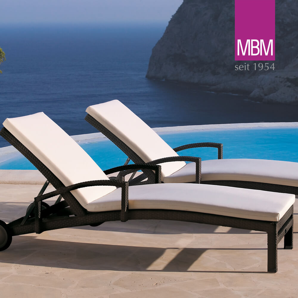 Deux lits de jardin rembourrés avec une structure noire au bord d'une piscine avec vue sur la mer