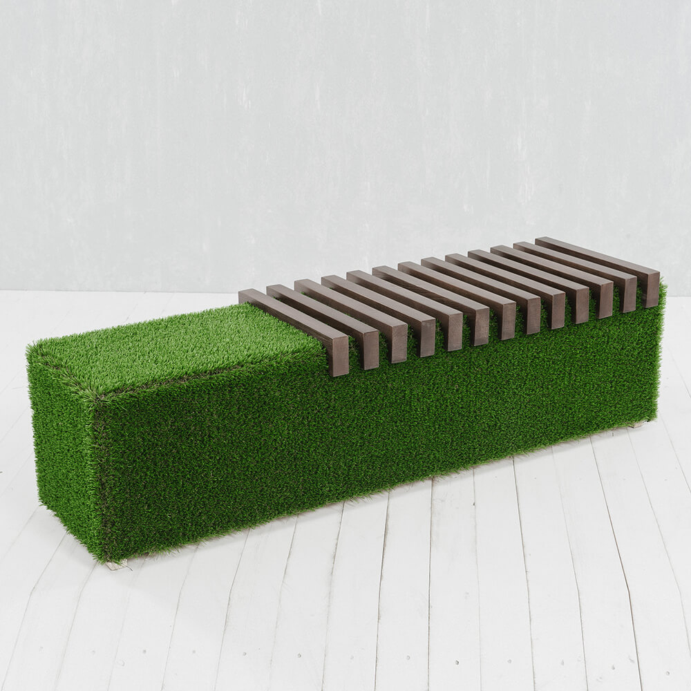 Panca da giardino con prato sintetico verde e doghe di legno marrone su pavimento bianco