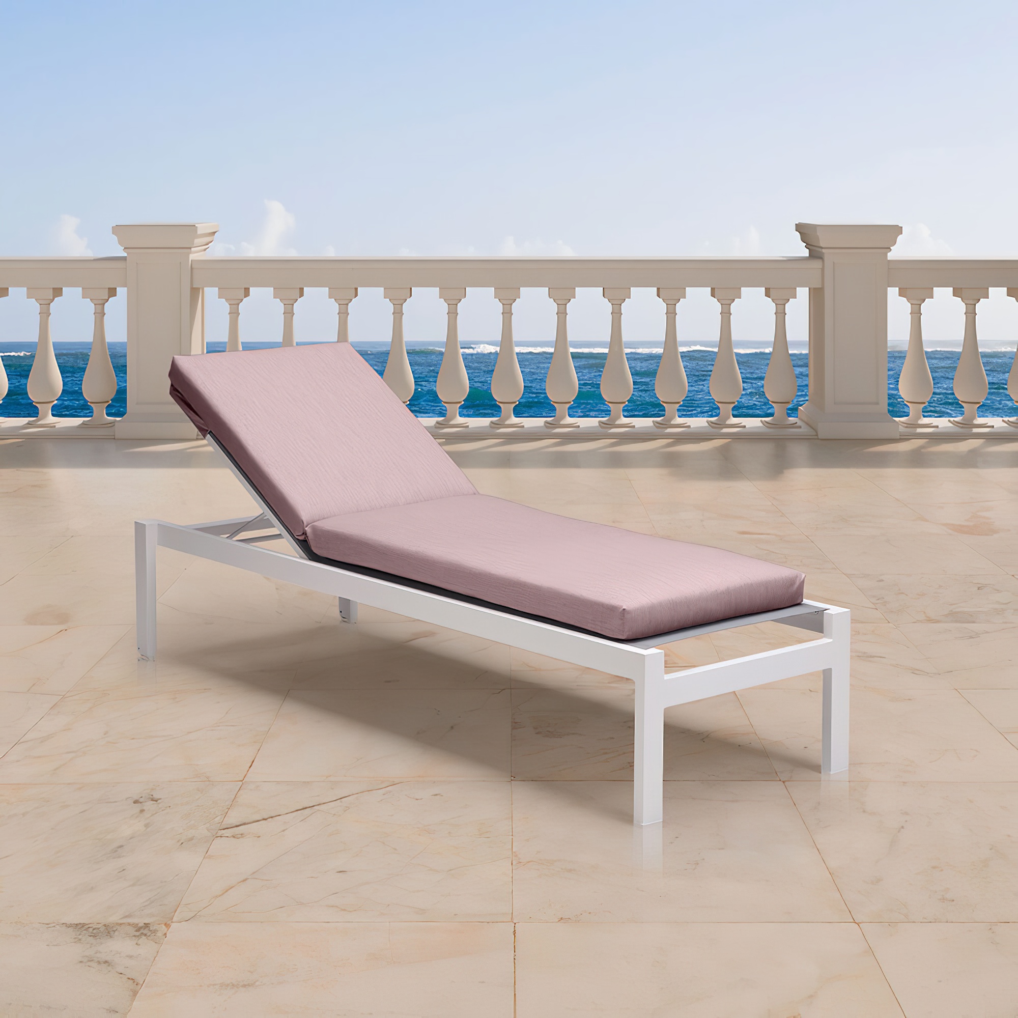 Chaise longue de jardin blanche avec coussin rose sur terrasse avec vue sur la mer