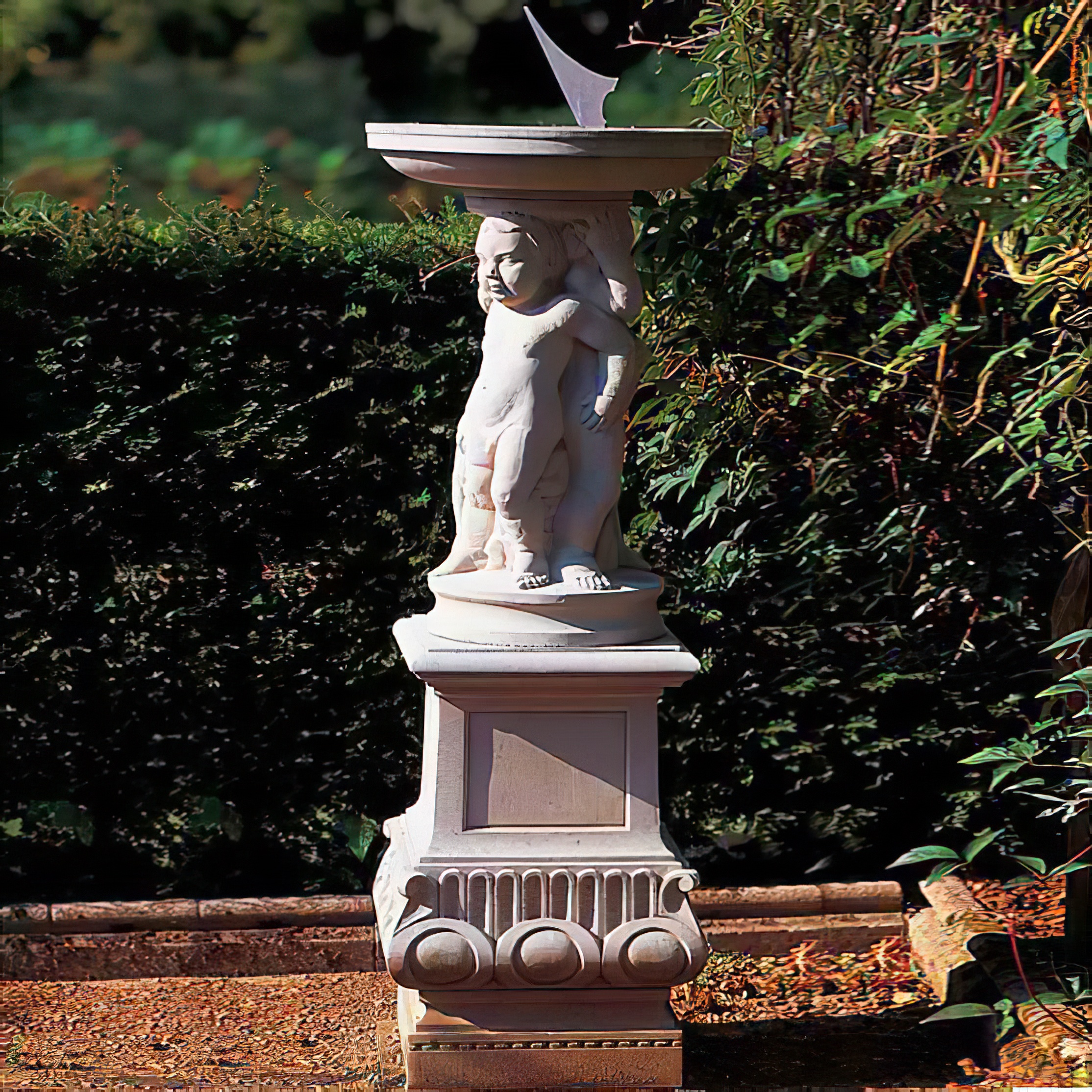 Meridiana in pietra con figura di putto nel giardino davanti a una siepe e cespugli