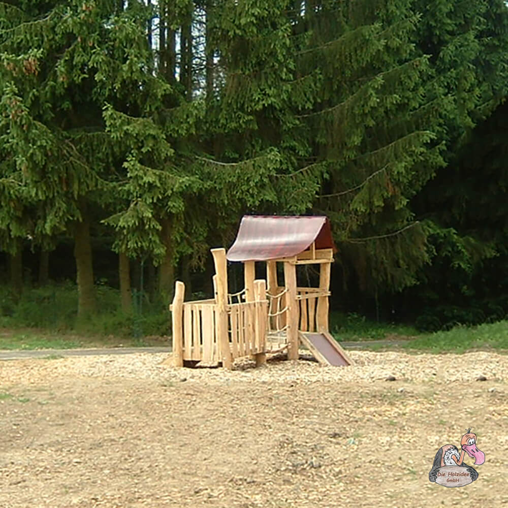 Kleines Spielhaus aus Holz im Garten vor Waldkulisse