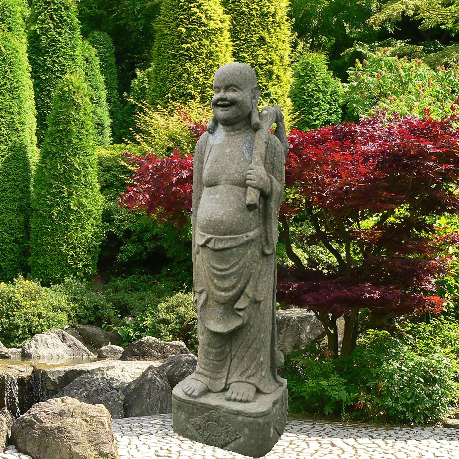 Statue de Bouddha en pierre dans un jardin avec des buissons verts et des feuilles rouges