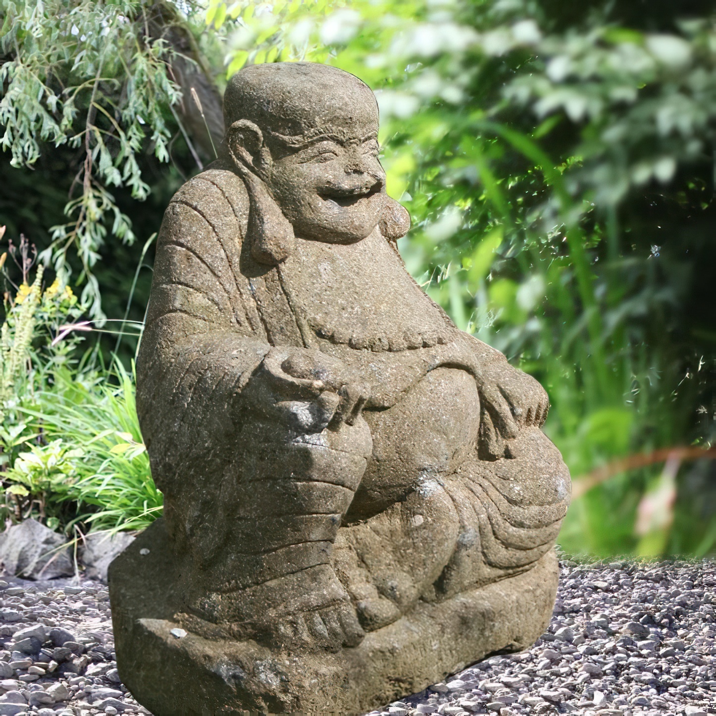 Statue de Bouddha en pierre dans un jardin verdoyant