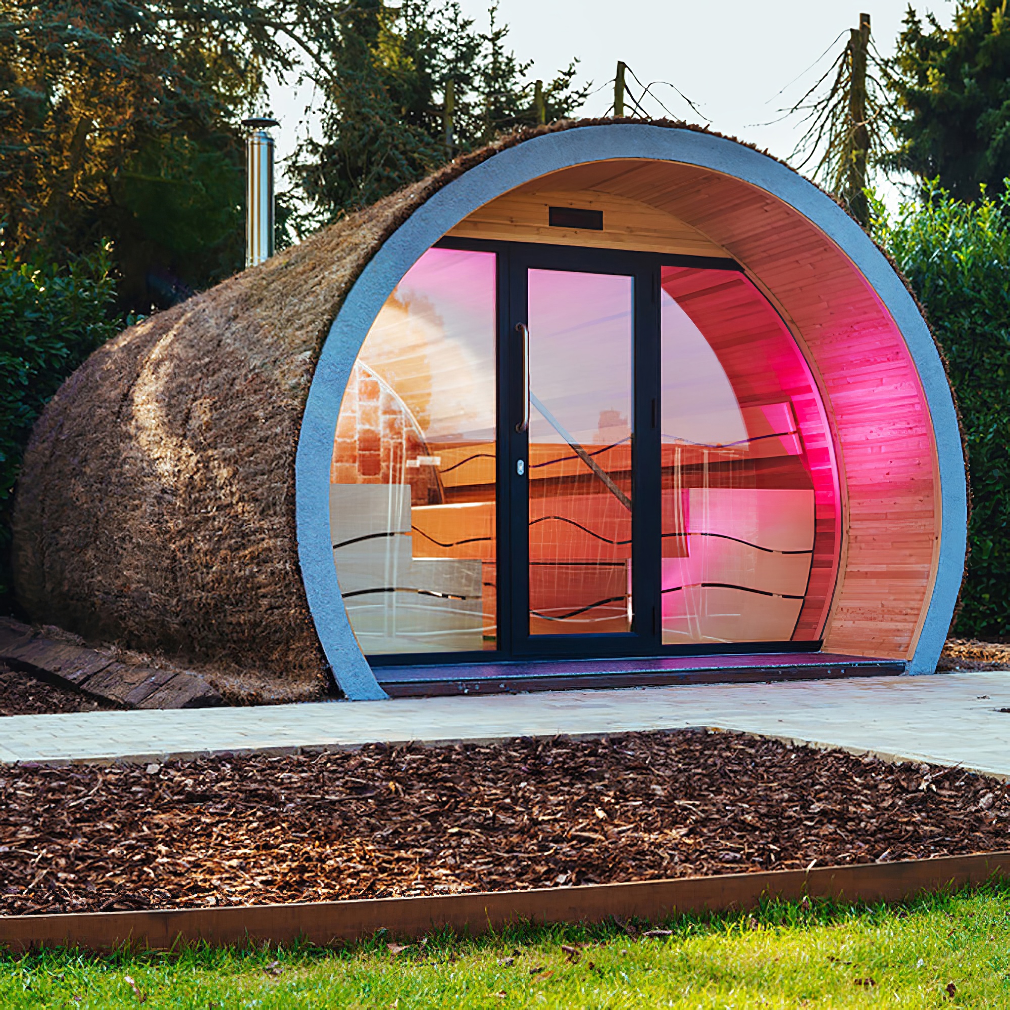 Modernes, rundes Gartenhaus mit beleuchteter Glasfront und Holzwänden im Garten