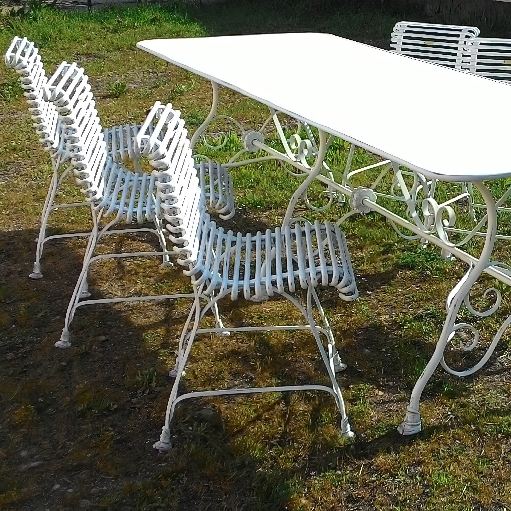 Exklusive weisse Metall-Gartenmöbel bestehend aus Tisch und Stühlen im Garten
