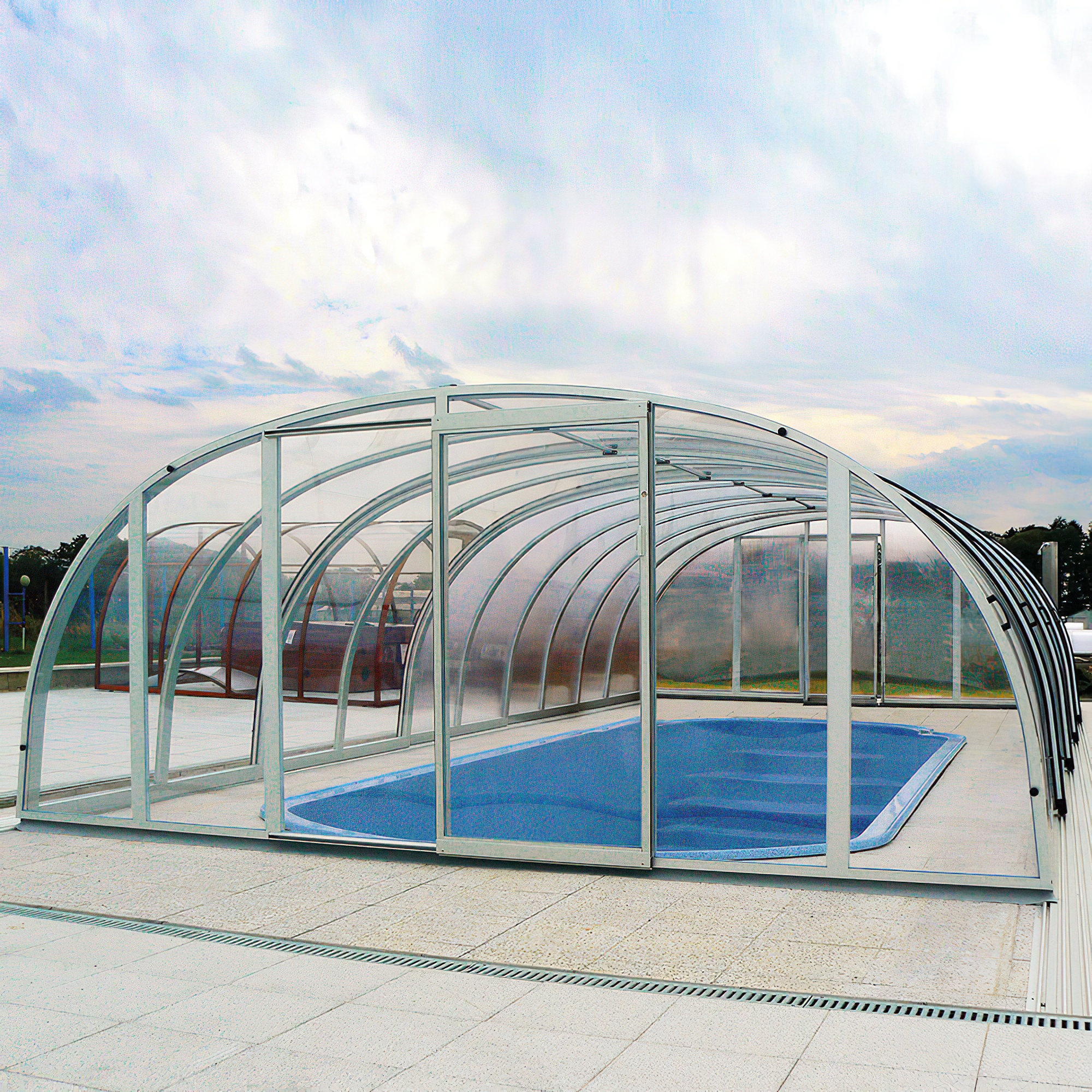 Couvercle transparent d'une piscine dans le jardin sous un ciel nuageux