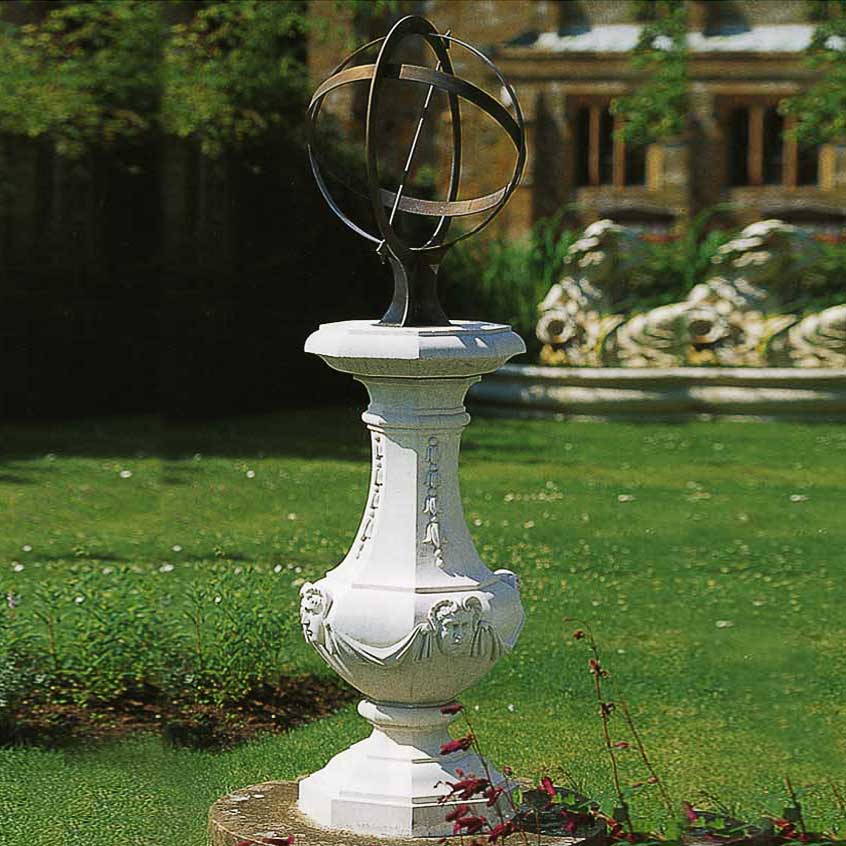 Meridiana in metallo elegante su piedistallo bianco ornato nel giardino verde
