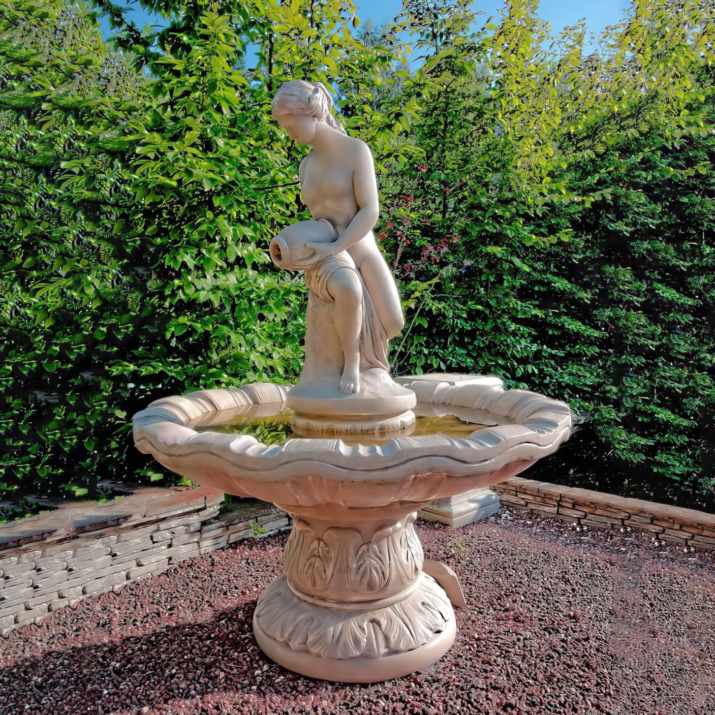 Eleganter Gartenbrunnen mit Statue einer Frau, umgeben von grünen Hecken