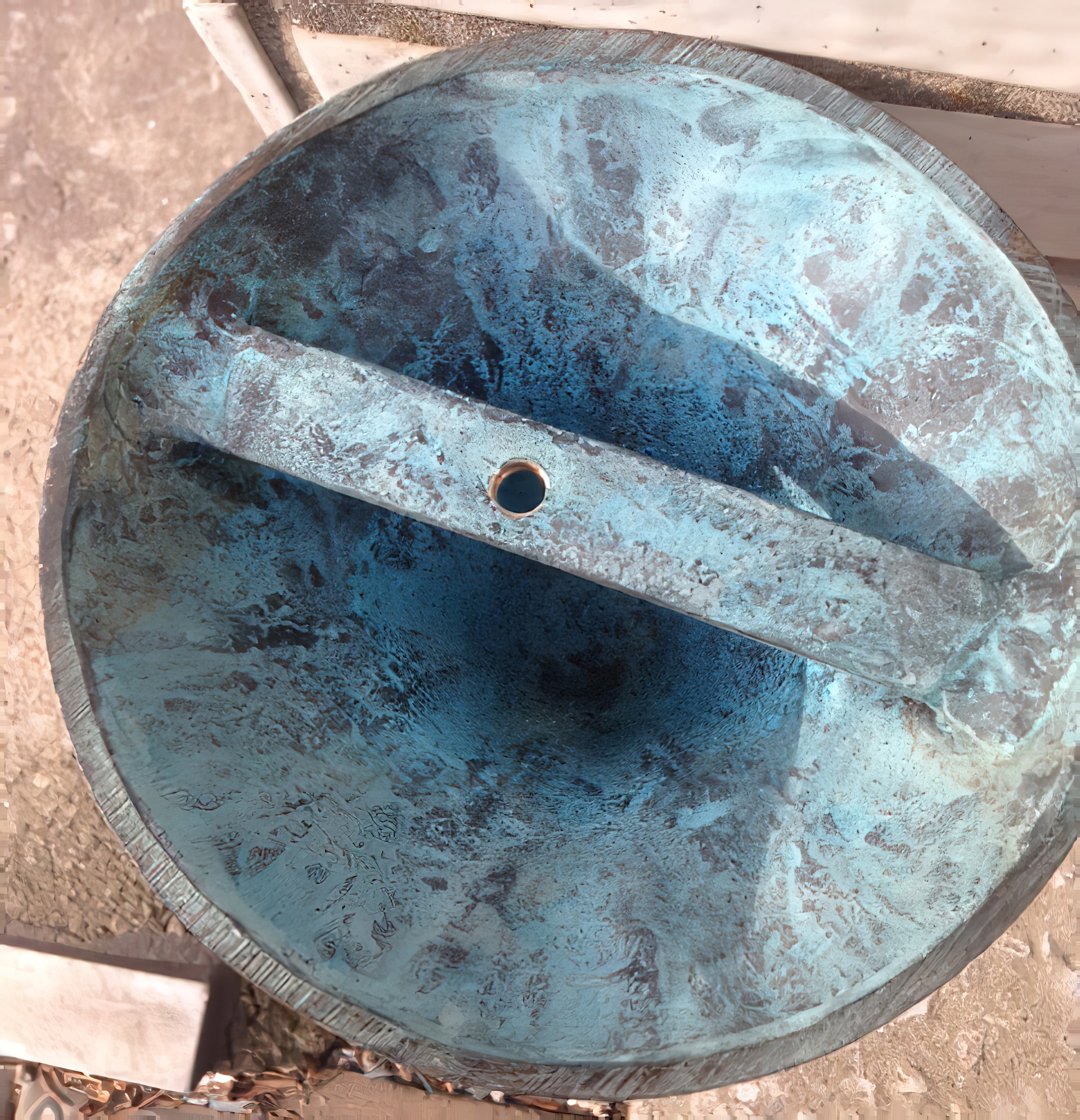 Runde Sonnenuhr mit Patina-Oberfläche und Metallstab in exklusiver Gartendekoration
