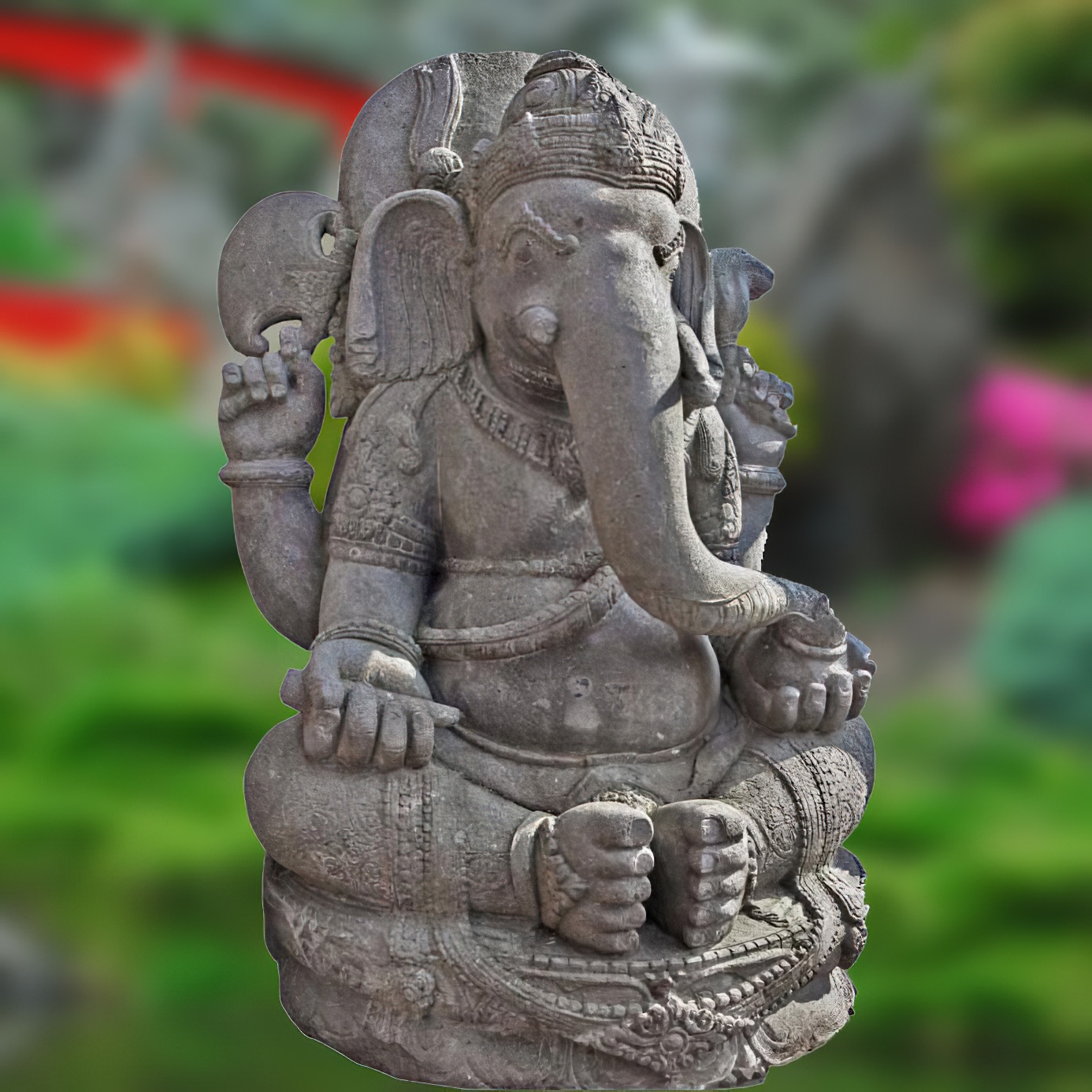 Statue de Ganesh en pierre comme décoration de jardin exclusive dans un jardin verdoyant