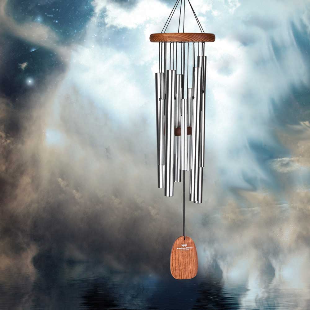 Carillon éolien avec tubes en aluminium et bois devant un ciel nuageux