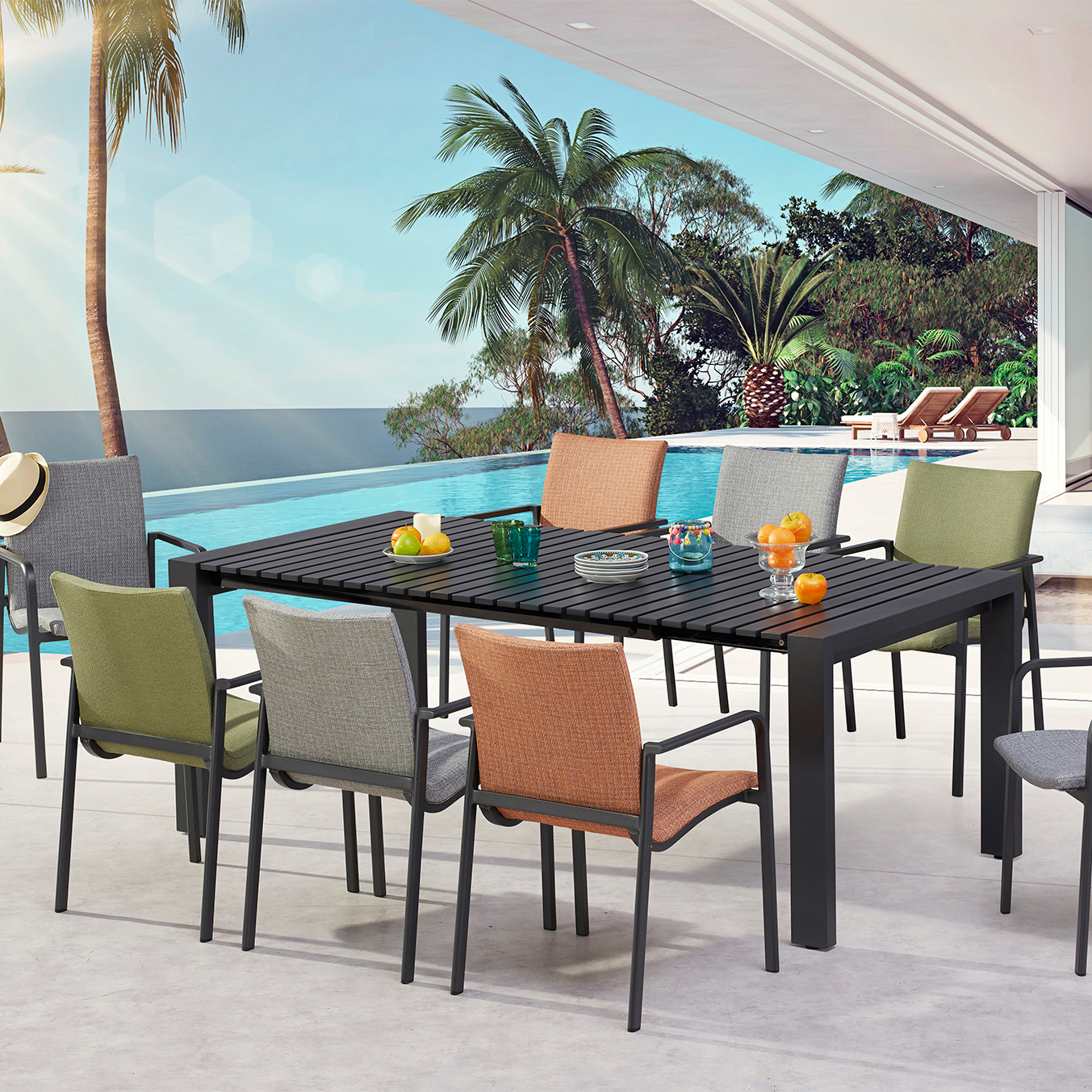 Table de jardin moderne avec chaises colorées sur la terrasse avec palmiers et vue sur la mer
