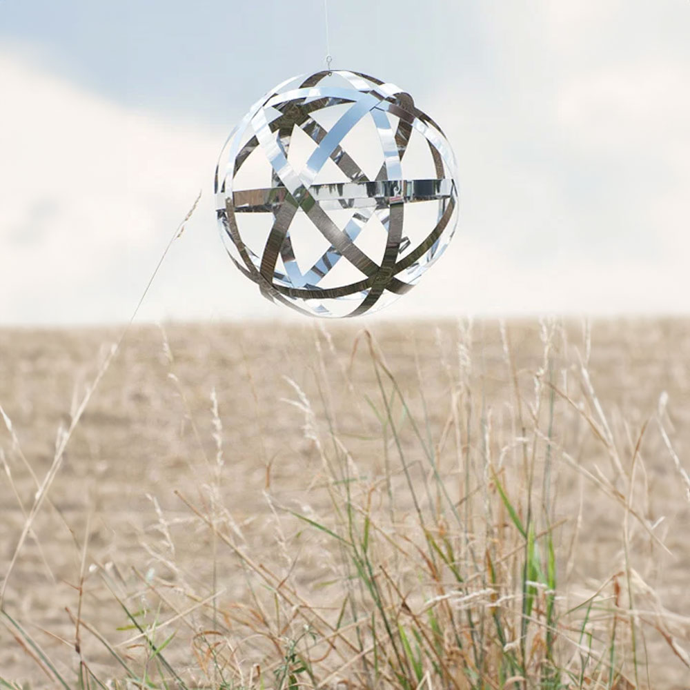 Edelstahl Kugel Gartendeko im Freien mit Hintergrund von Feldern und Gras