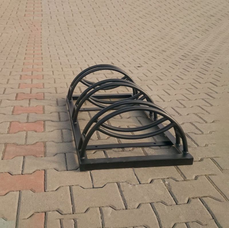 Support à vélos en métal noir sur sol pavé en extérieur