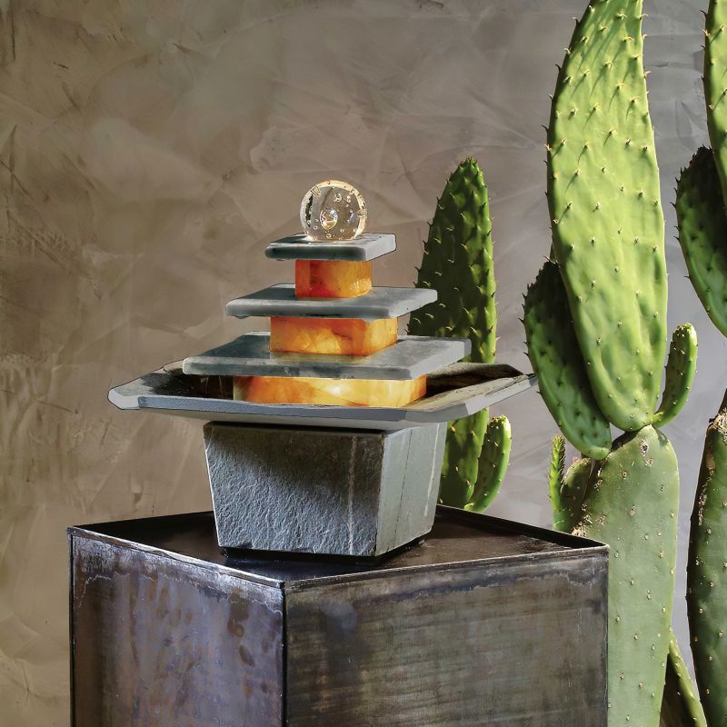 Sculpture de jardin élégante en acier inoxydable avec cubes en verre devant plante verte