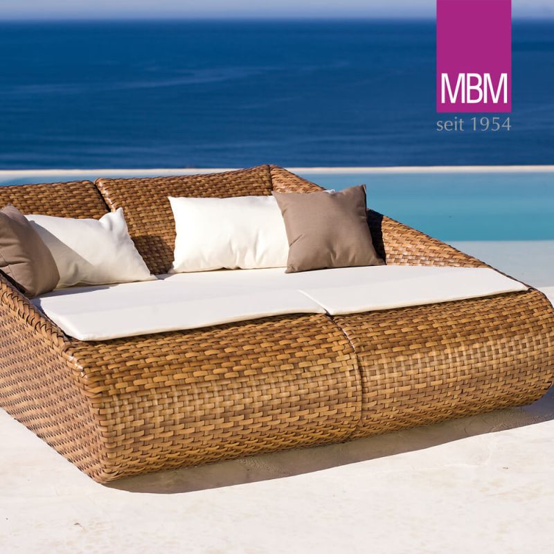 Chaise double moderne en rotin avec coussins au bord de la mer