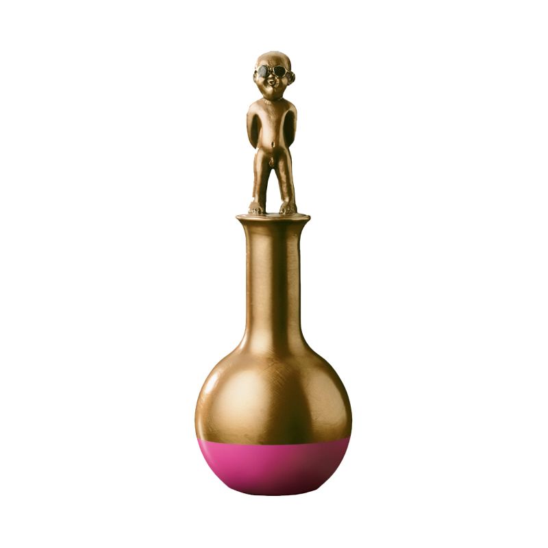 Figure en bronze d'un enfant debout sur un vase rond avec un fond rose dans le jardin