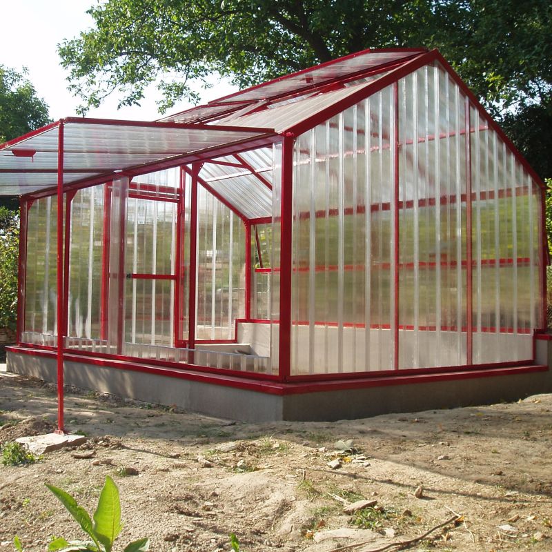 Serre moderne rouge avec murs et toit en verre dans le jardin