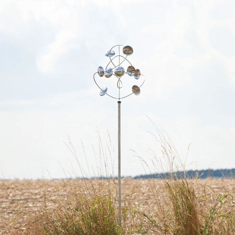 Moderna scultura da vento con sfere rotanti in un campo, decorazione da giardino